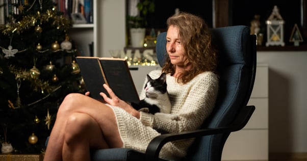 femme et son chat lisent un livre à Noël