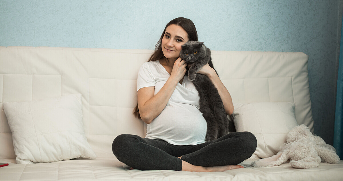 pregnant woman cuddling cat