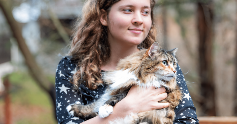 Frau hält Katze auf dem Arm